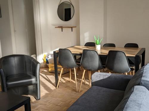 uma sala de jantar com uma mesa e cadeiras pretas em L'Effet-Mer em Dunkerque