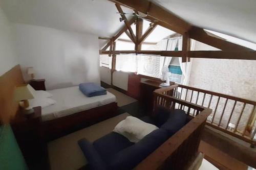 een kamer met 2 bedden en een blauwe bank. bij Grande maison de famille avec piscine couverte in Nieulle-sur-Seudre