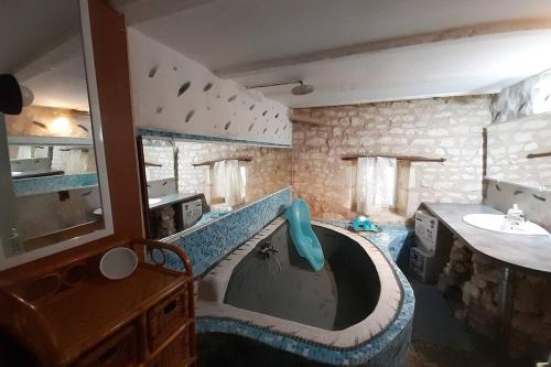 een badkamer met een wastafel en een bad bij Grande maison de famille avec piscine couverte in Nieulle-sur-Seudre