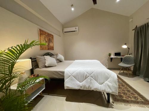 a bedroom with a bed and a desk and a plant at NomadGao Vila Nova - Comfort, Great Views, Fast WiFi & Interesting People in Anjuna