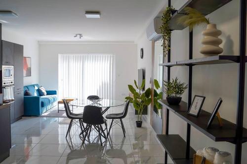 a living room with a table and chairs in it at Luxurious Apartment Next to the Sea in Il-Gżira