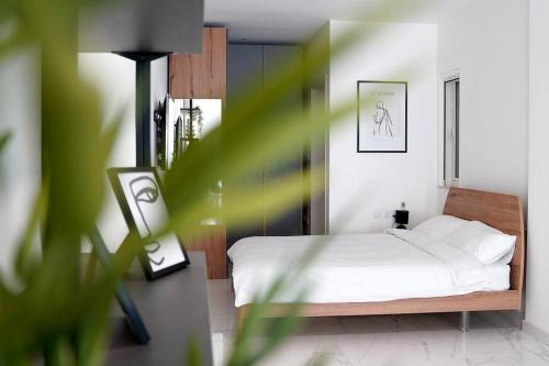 a bedroom with a bed with white sheets at Luxurious Apartment Next to the Sea in Il-Gżira