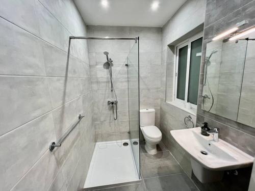 a bathroom with a shower and a toilet and a sink at Luxurious Apartment Next to the Sea in Il-Gżira