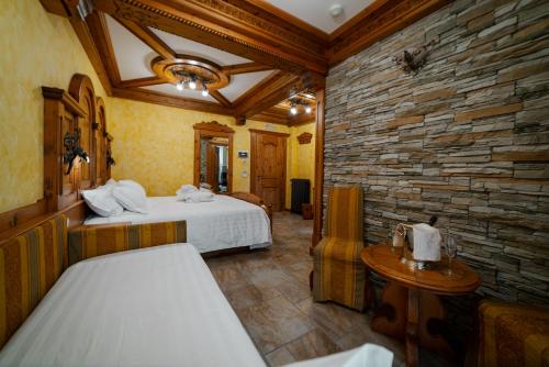 a bedroom with two beds and a stone wall at Hotel Le Ortensie in Roccaraso