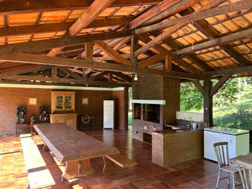 Sítio Mato Dentro في أتيبايا: مطبخ كبير مفتوح بسقف خشبي كبير
