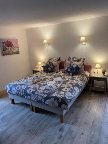 a bedroom with a bed and two tables with lamps at DOMAINE DE LA RESERVE in Coublanc