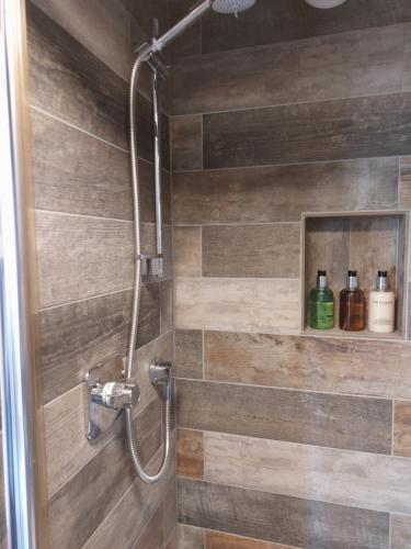 a bathroom with a shower with a wooden wall at Ellerhow in Windermere