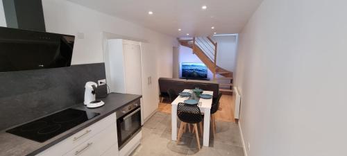 une petite cuisine avec une table et un escalier dans l'établissement L'Appart Oytier Saint Oblas+Parking gratuit, à Oytier-Saint-Oblas
