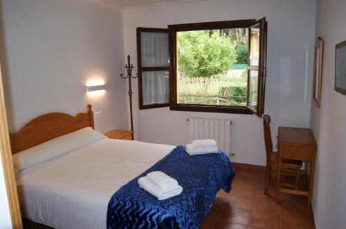 a bedroom with a bed and a desk and a window at Apartamentos Camin De Pelayo in Las Rozas