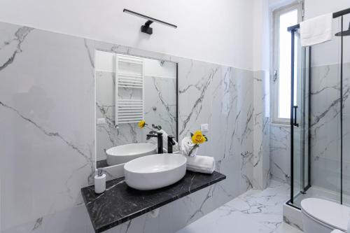 a white bathroom with a sink and a mirror at Re di Roma Rooftop in Rome