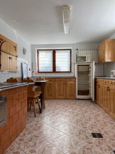 a kitchen with wooden cabinets and a table in it at Domek Okno na Tatry - Dom na wyłączność in Poronin