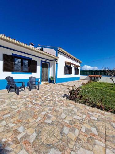 a patio with two benches in front of a house at Bouro's Cliff in Serra do Bouro