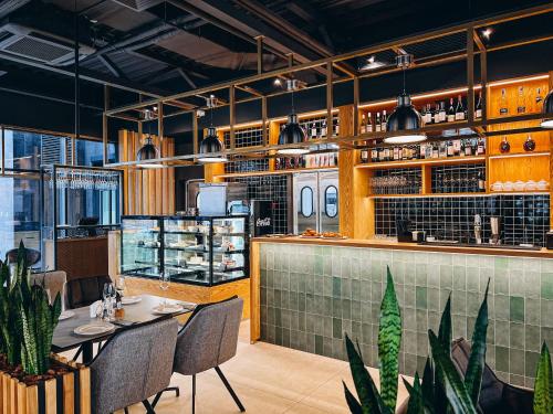 un ristorante con tavolo e sedie e un bar di Favor Sport Hotel a Kiev