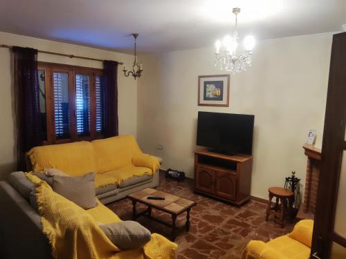 un soggiorno con divano e TV di CASA EL LAUREL a Vélez-Rubio
