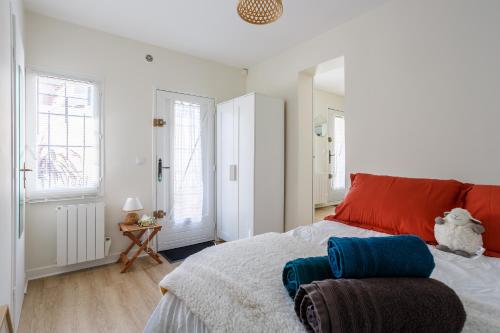 - une chambre avec un lit doté d'oreillers rouges et bleus dans l'établissement LA TERRASSE - FIBRE - PARKING GRATUIT - Proche écoles et entreprises, à Orsay