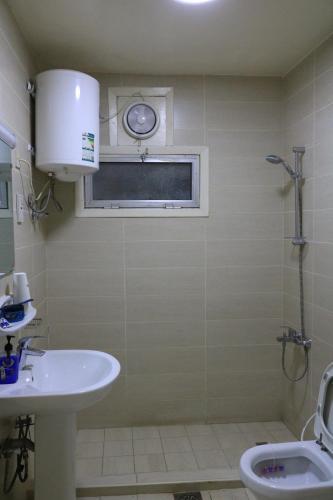 a bathroom with a sink and a toilet and a window at Sakhra hostel in Dubai