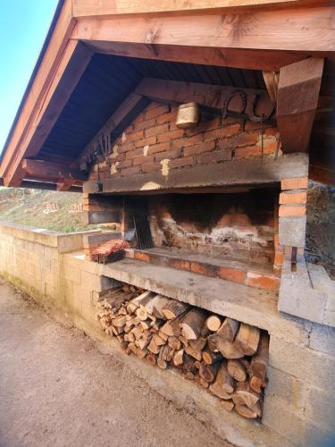 a pile of fire wood in a brick wall at Vikendica Cokori in Banja Luka