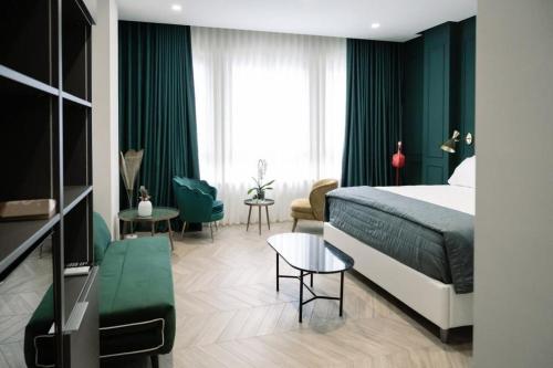 una camera d'albergo con letto e tende verdi di Salotto Room Boutique a Pescara