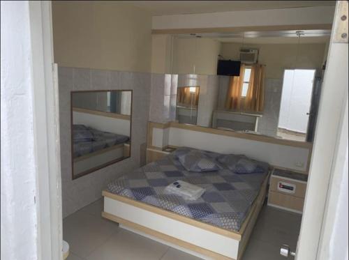 een kleine slaapkamer met een bed en een spiegel bij Hotel Central in Niterói