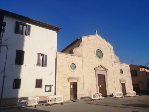 a large white building with chairs in front of it at Dimora Storica Torre degli Arduini, San Giacomo, Spoleto in San Giacomo
