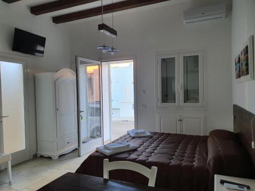 a living room with a bed and a table in it at Lu Salentu Chalet Beach in Marina di Mancaversa