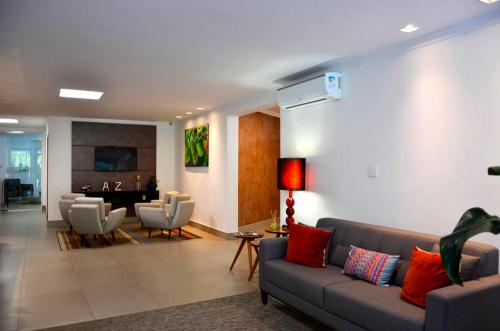 a living room with a couch and chairs at Hotel Bertell Inn in Penedo