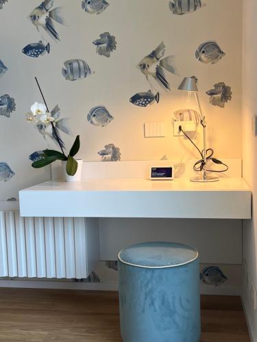 a room with a desk with a lamp and a blue trash can at About Italy Holiday Rooms and Apartments in Portovenere