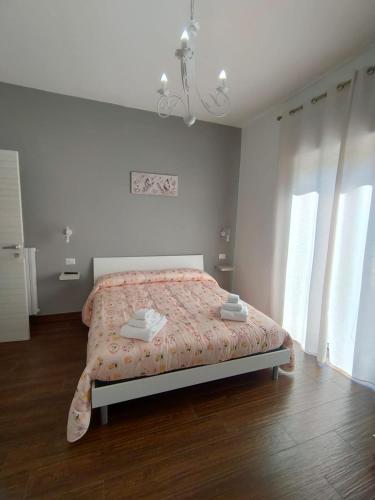 a bedroom with a bed with a pink comforter at Desidora B&B in Mirabella Eclano