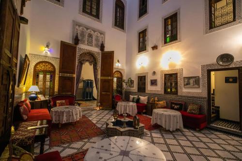 Riad Arabella في فاس: غرفة معيشة مع كنب وطاولات في مبنى