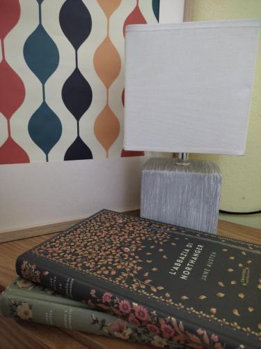 una lámpara sentada encima de dos libros sobre una mesa en Piccolo Hotel Nuova gestione, en Cala Gonone