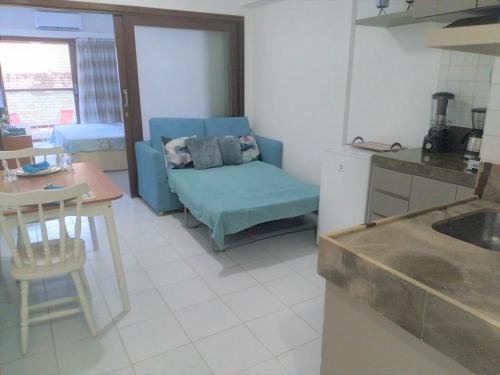 cocina con sofá azul y mesa en Flat a beira mar, vista lateral - Araça 408, en Natal