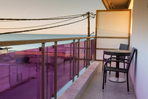 a balcony with a table and a view of the ocean at Hotel Pithari in Agia Triada
