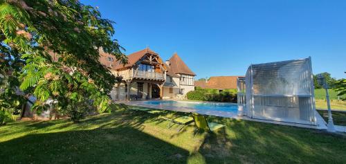 a house with a swimming pool in the yard at La Ferme de Laupilière in Sarrazac