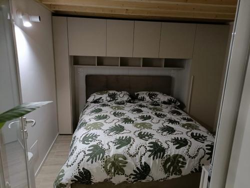 un letto in una piccola camera con copriletto di SABOTINO APARTMENT a Civitanova Marche