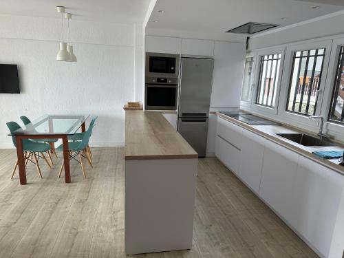 een keuken en eetkamer met een tafel en stoelen bij BURUMENDI 4 in Mutriku