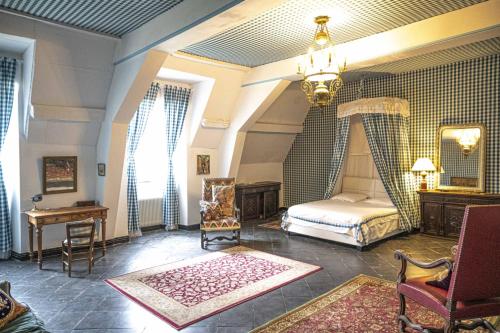 une chambre avec un lit et un lustre dans l'établissement Château du Boschet chambre de l’infatigable gentilhomme, à Bourg-des-Comptes