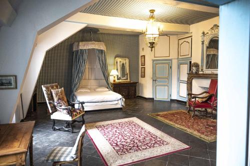 une chambre avec un lit, une table et des chaises dans l'établissement Château du Boschet chambre de l’infatigable gentilhomme, à Bourg-des-Comptes