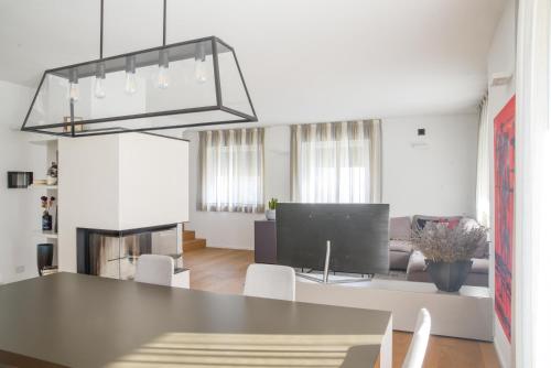 a kitchen and living room with a table and a television at Casa Riccardo in Levico Terme