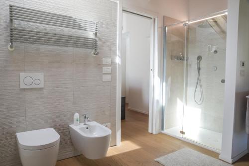 a bathroom with a toilet and a sink and a shower at Casa Riccardo in Levico Terme