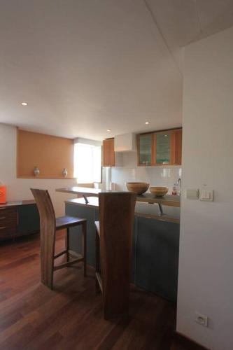 - une cuisine avec un îlot doté de chaises et d'une table dans l'établissement Apparemment au cœur de St tropez, à Saint-Tropez