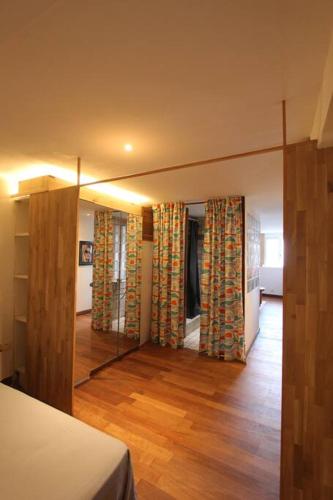 Cette chambre dispose d'un miroir, d'un lit et de parquet. dans l'établissement Apparemment au cœur de St tropez, à Saint-Tropez