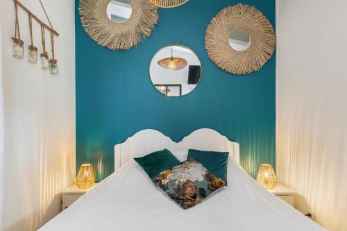 - une chambre dotée d'un lit avec des murs bleus et des miroirs dans l'établissement Eureka emeraude, au Cap d'Agde