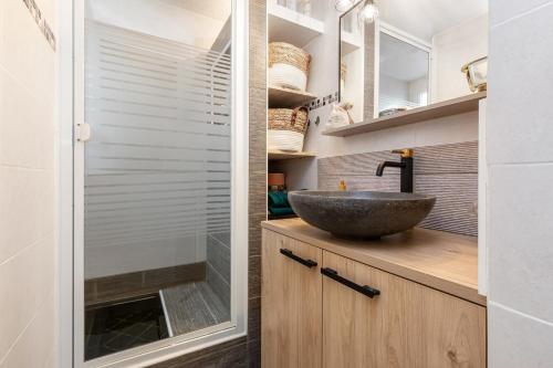 La salle de bains est pourvue d'un lavabo et d'une douche en verre. dans l'établissement Eureka emeraude, au Cap d'Agde