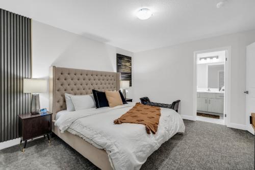a white bedroom with a large bed and a window at Lavish Home on Scenic Mountain - King Bed in Hamilton