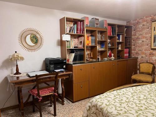 Casa fra gli ulivi di Giuseppe في Sonnino: غرفة نوم مع مكتب ورف كتاب