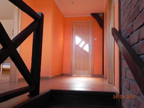 un pasillo con paredes de color naranja y una puerta en Dom Nad Jeziorem Łąkorz en Łąkorz