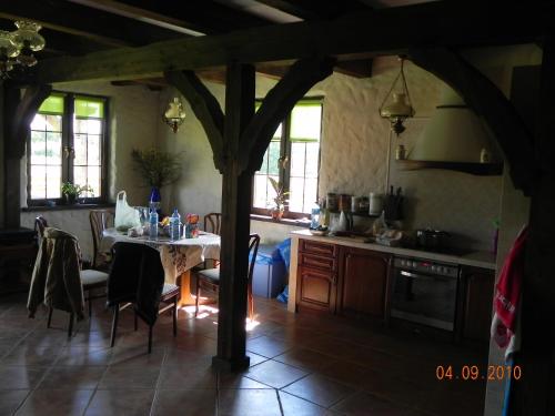 eine Küche mit einem Tisch und Stühlen im Zimmer in der Unterkunft Dom Nad Jeziorem Łąkorz in Łąkorz