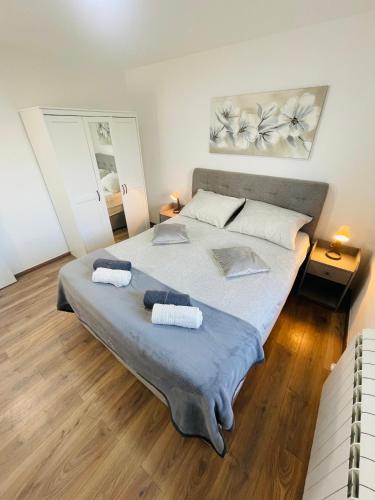 een slaapkamer met een groot bed en 2 handdoeken bij Muki apartments in Surčin