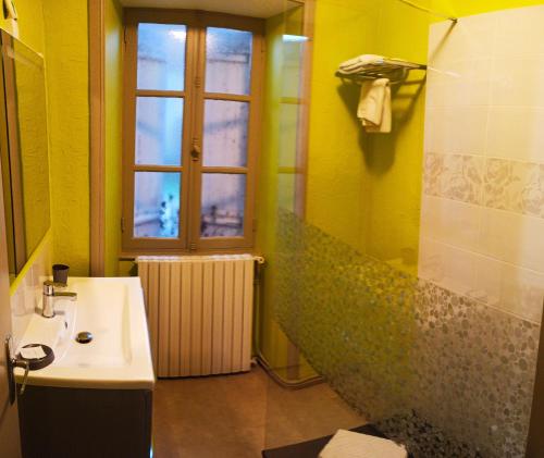 a bathroom with a sink and a shower with a window at La Ferme de Laupilière in Sarrazac