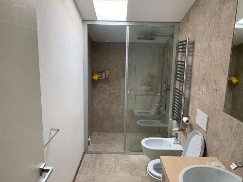 a bathroom with two sinks and a shower at Ampio Appartamento con vista lago, sauna e camino Golf club Margara in Fubine